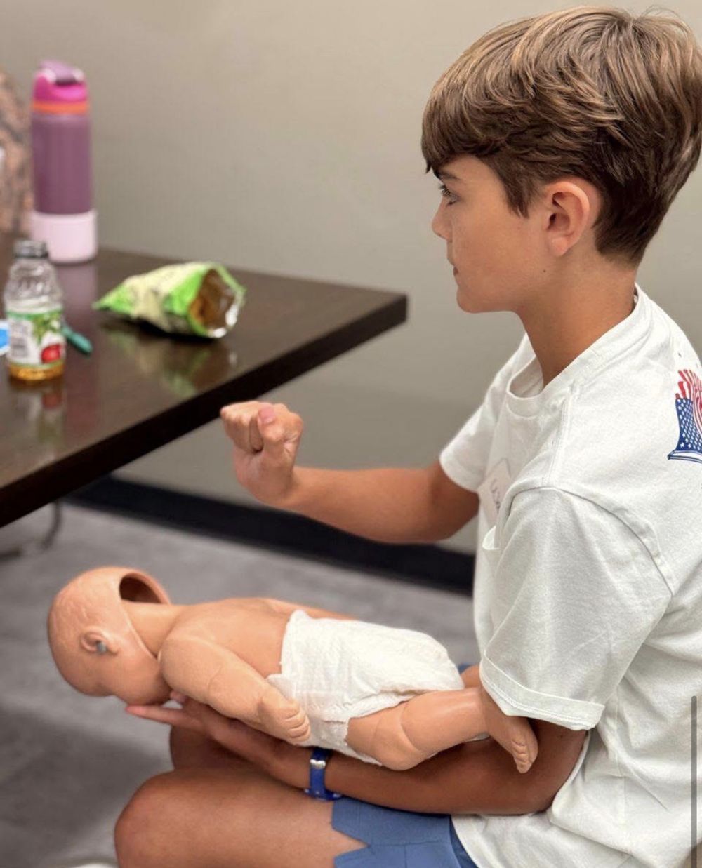 A student practicing infant choking rescue on a practice doll